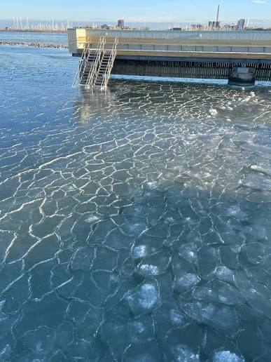 Istäckt vatten vid Sibbarps kallbadhus under en klar vinterdag