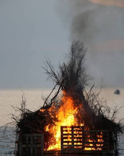 Majbrasan brinner ute i Öresund vid Sibbarp under valborgsfirandet